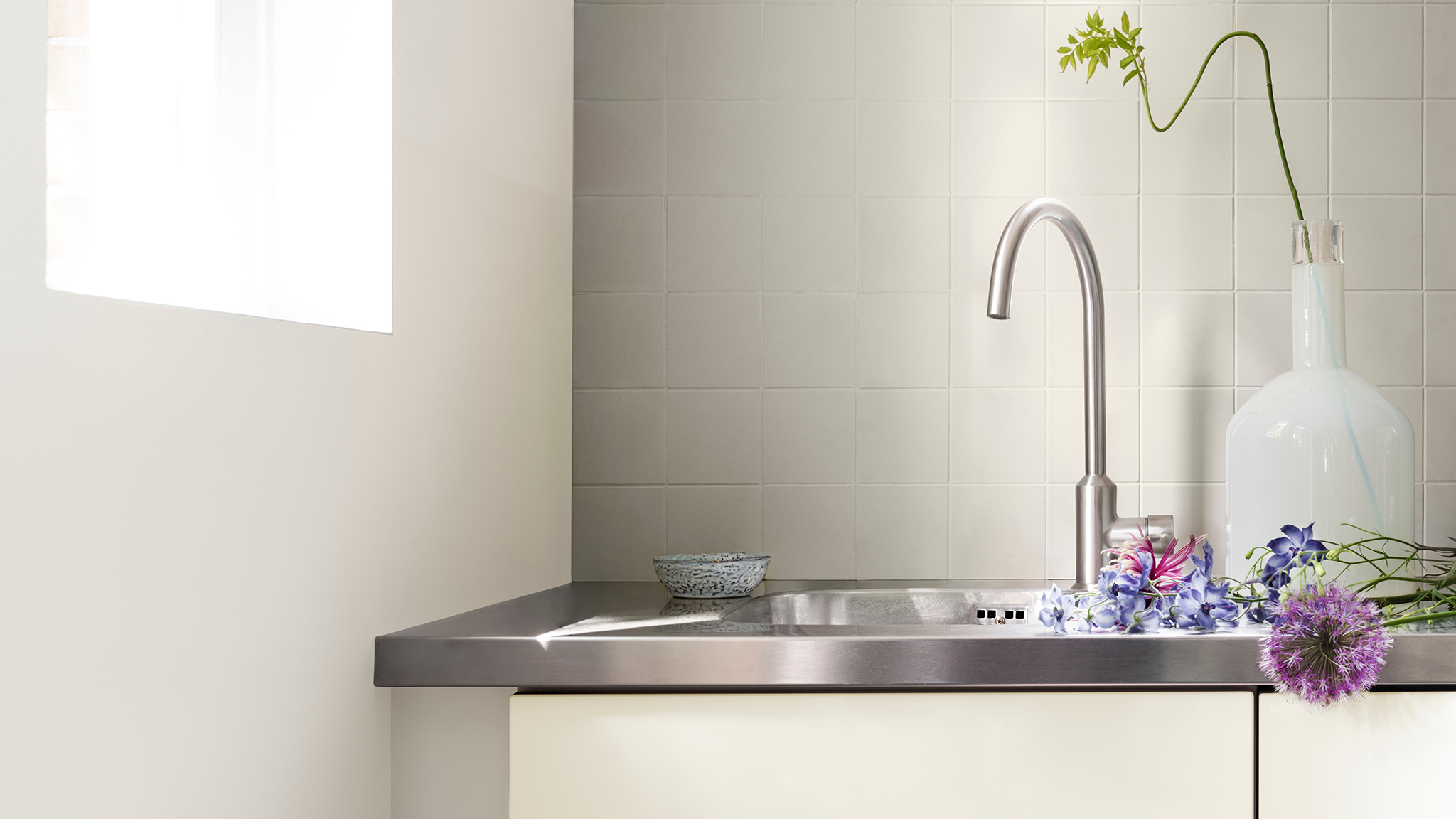Taupe wall with cream cabinets and a metal sink. dulux-simply-refresh-tiles-ideas-global-2