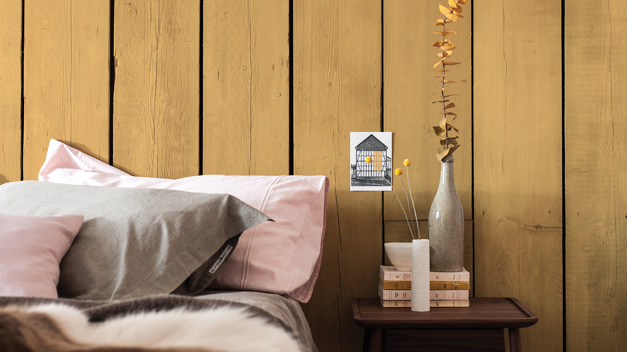 Yellow paneling with pink bedding and a wooden bedside table dulux-simply-refresh-wall-panels-ideas-global-4